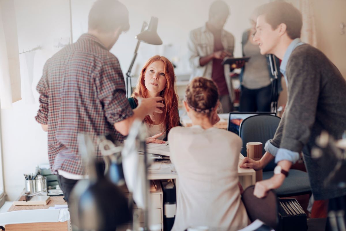 Group of employees talking around a desk