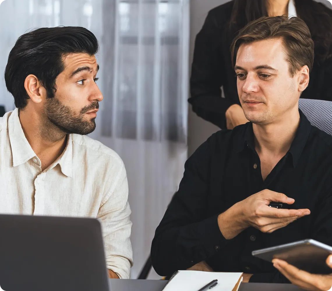 Discussing work with his colleague.